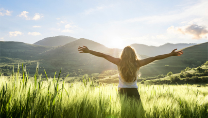 Woman embracing a sunny field